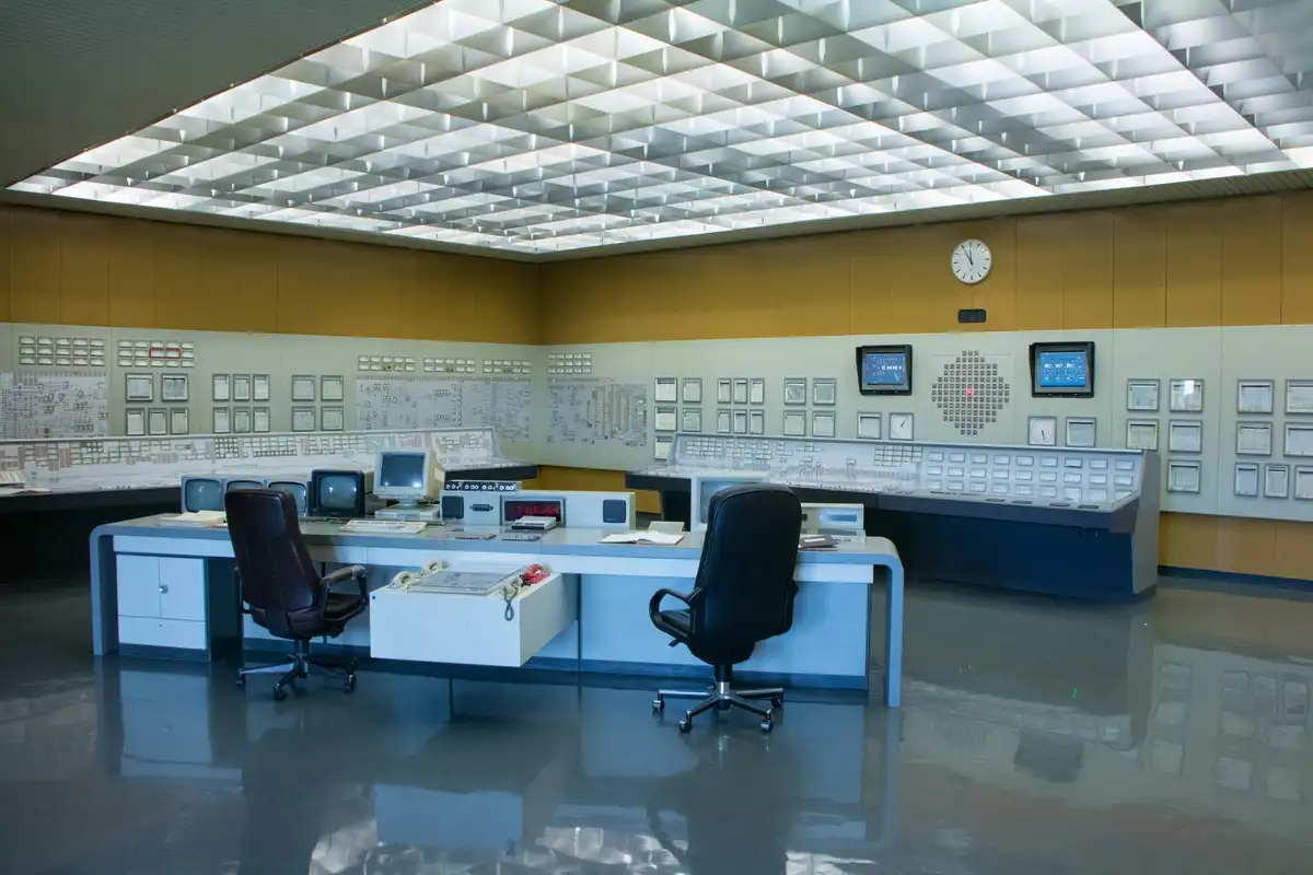 Industrial control room with instrument panels and a central operator desk